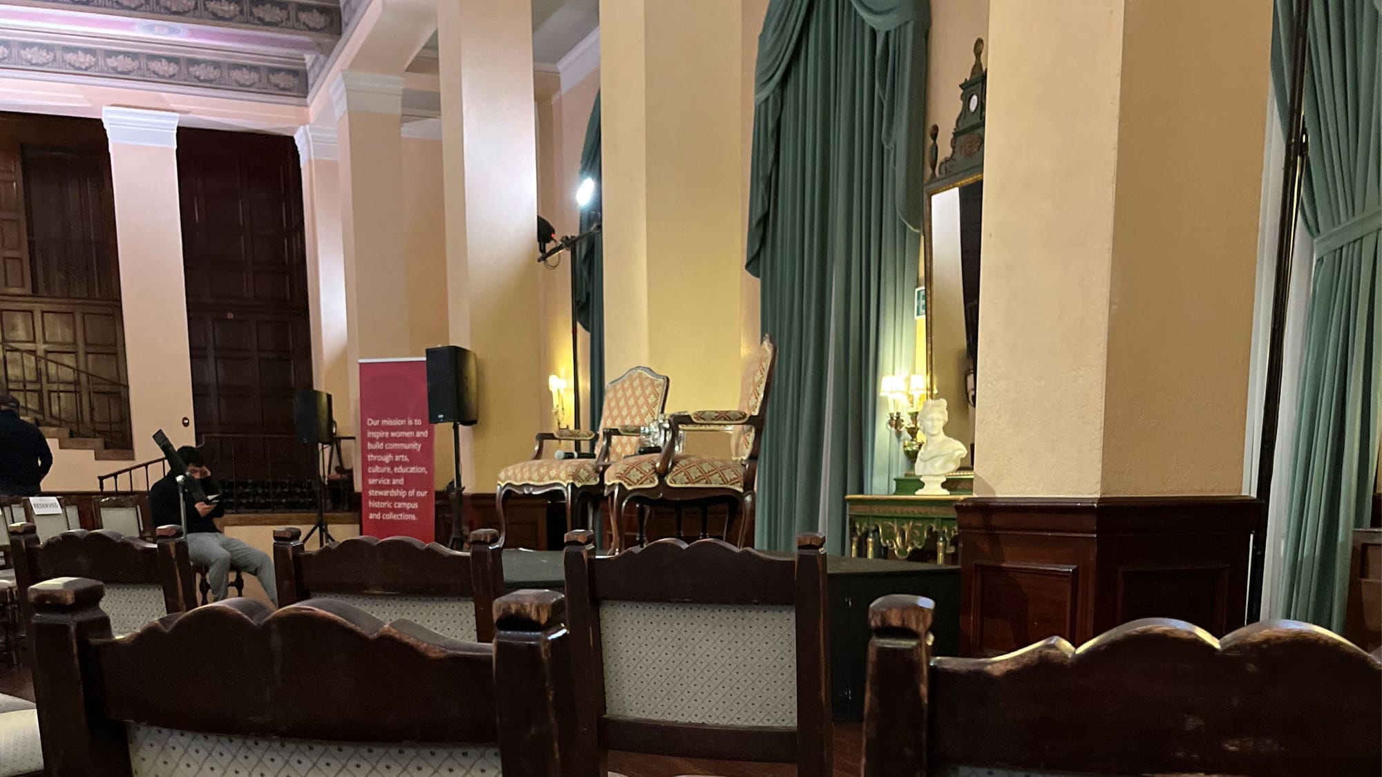 An elegant gathering about to begin at the Ebell Theater, a classic LA landmark, with two upholstered French armchairs on a dais awaiting speakers and audience chairs set up below