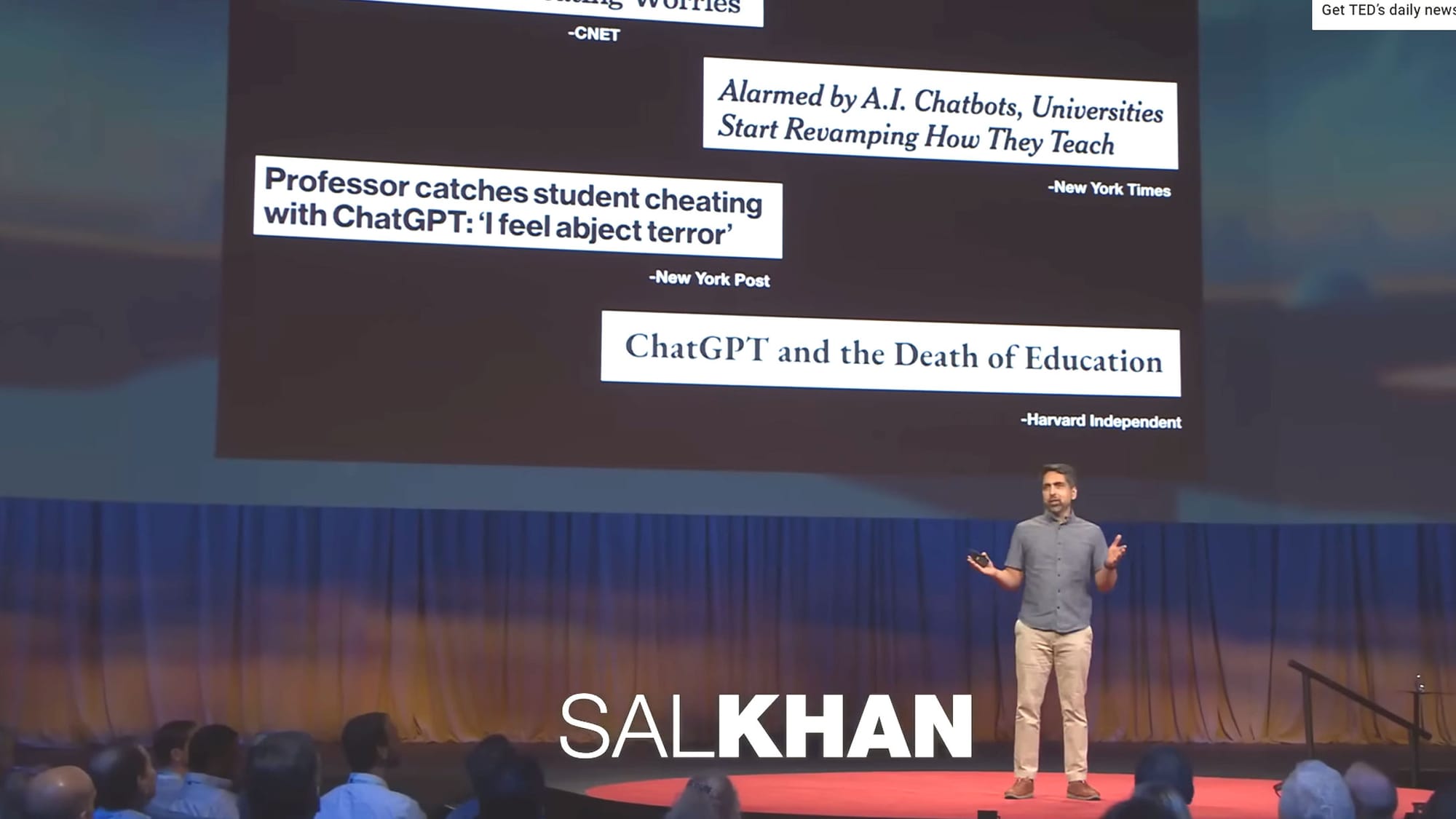Screenshot of Sal Khan's TED talk from Spring 2023 introducing his new AI tutoring program, Khanmigo: a screen above him quotes news stories expressing skepticism about ChatGPT and the threat posed by AI to education, including, "Alarmed by A.I. Chatbotx, Universities Start Revamping How They Teach," "Professor catches student cheating with Chat GPT: 'I feel abject terror,'" and "ChatGPT and the Death of Education"