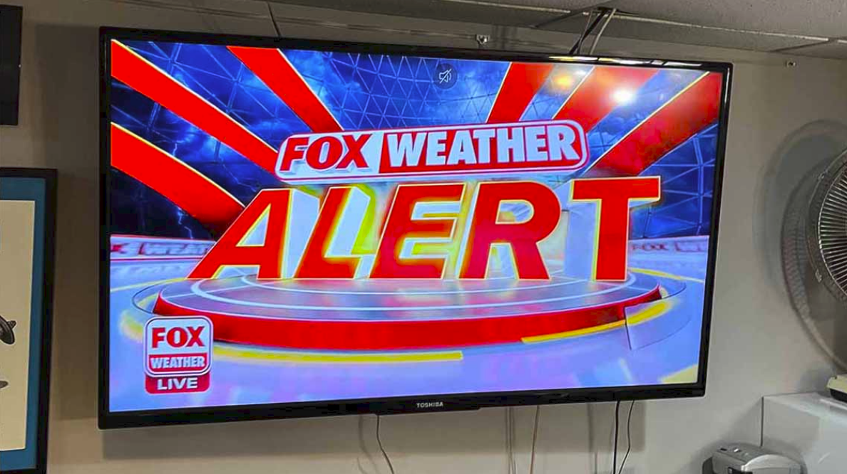 TV SCREEN: FOX WEATHER ALERT FOX WEATHER LIVE, glowing red and yellow with red rays emanating pure panic