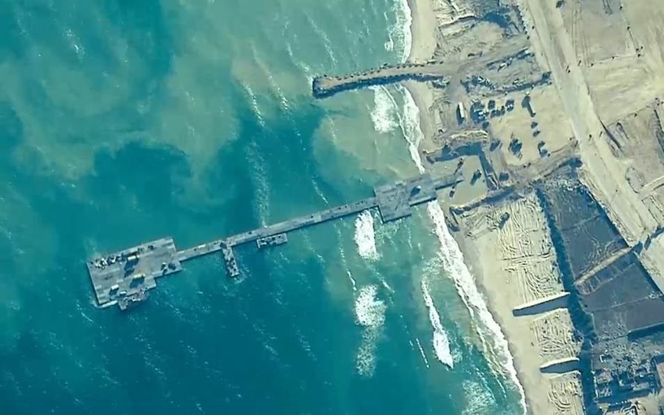 Overhead image of the pier built by the U.S. to deliver humanitarian aid to Gaza, which is being razed to the ground by U.S. weapons