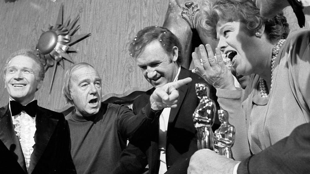 Academy Award winner Gene Hackman cuts cake on set of his new film, The Poseidon Adventure, at 20th Century Fox. Cast members who'd previously won Oscars join in celebration. From left are Red Buttons, Ronald Neame (director), Hackman, Shelley Winters and Ernest Borgnine. Hackman won an Oscar for role as a tough detective in The French Connection.