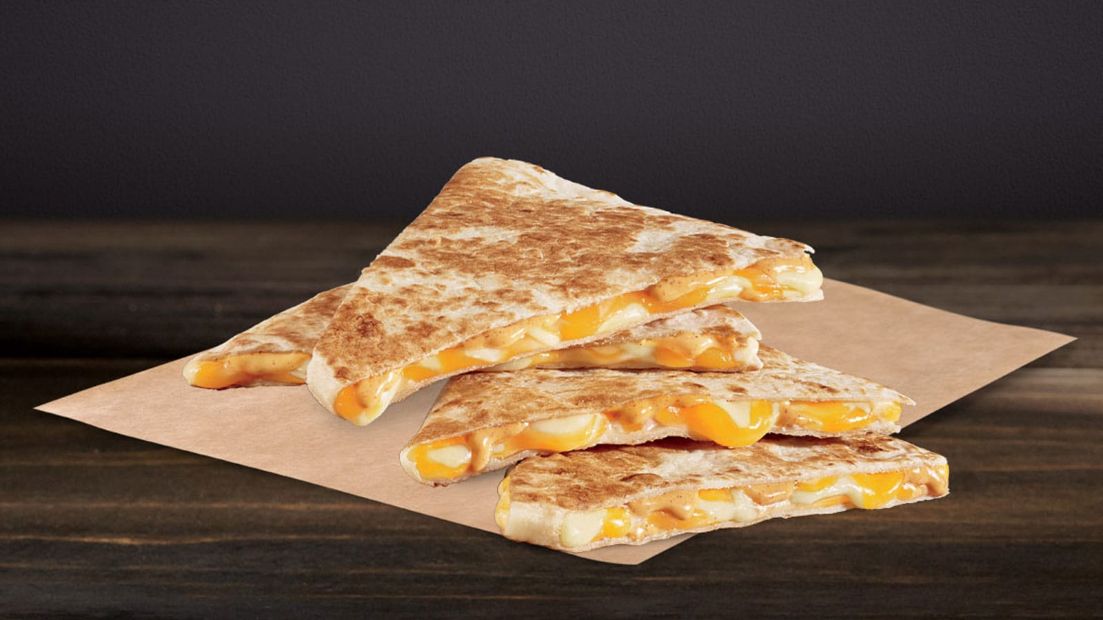 Luscious looking Taco Bell cheese quesadilla on a brown paper wrapper