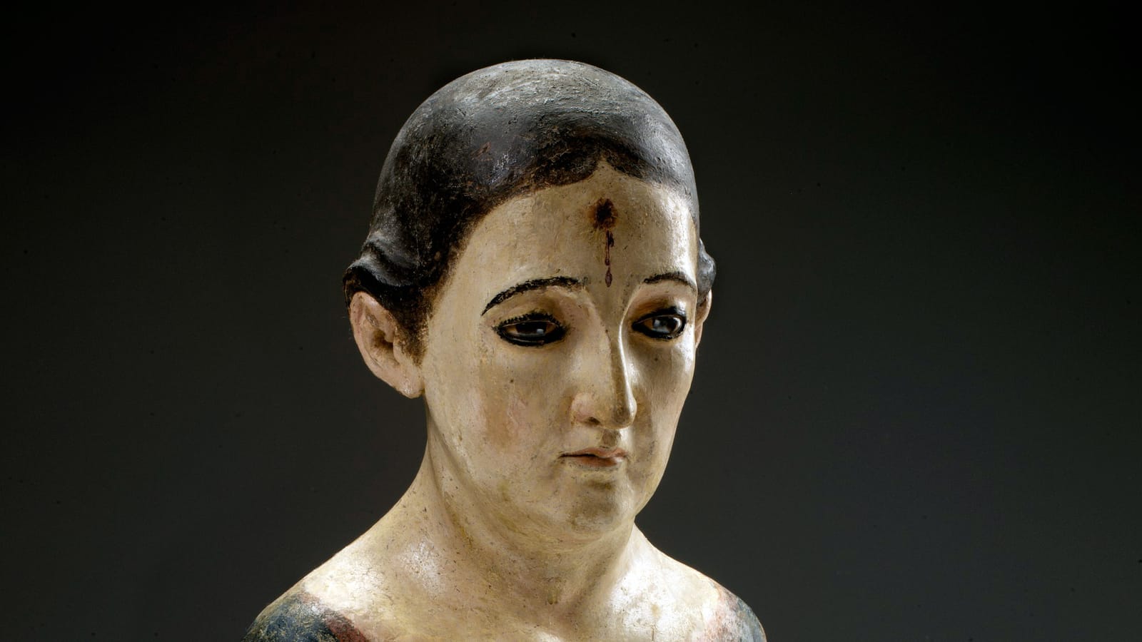 Conservation of this santo revealed red marks representing blood and a faded trace of a thorn on the figure’s forehead beneath layers of paint. These are symbols of St. Rita, who spent her days meditating on Christ’s sacrifice at the Monastery of the Hermits of Saint Augustine in Casia, Spain. This santo is meant to be dressed with textiles representing her habit. Her arms have been lost and she no longer wears a wig. The figure was found in a peasant home in the rural district of Minillas in San Germán, Puerto Rico.